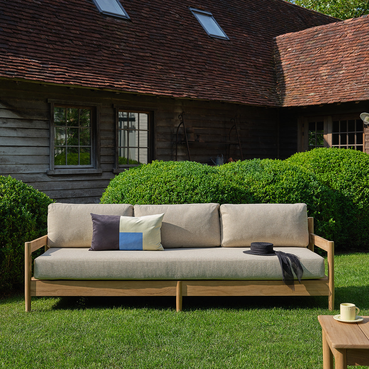 CALVI - Divano da giardino basso in teak massiccio con cuscini beige screziati, 4 posti.